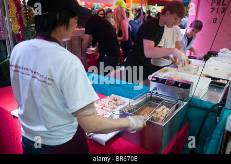 Köche beeilen, um zu halten mit der Nachfrage nach Frühlingsrollen auf dem malaysischen Nachtmarkt im Meatpacking District in New York Stockfoto