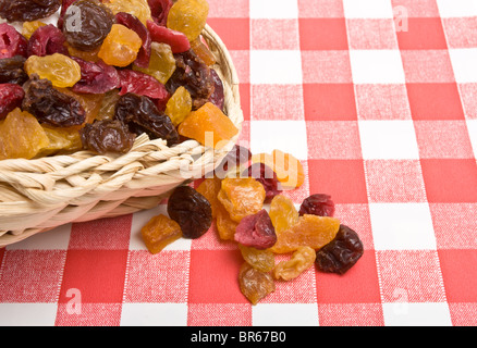 Getrocknete Früchte von Aprikose, Sultaninen, Rosinen und Cranberries Verschütten auf rote und weiße Tischdecke. Stockfoto