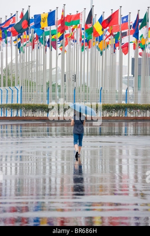 Reflexion der Menschen und Flag Pole auf dem Boden im Regen, Expo 2010 Shanghai, China Stockfoto