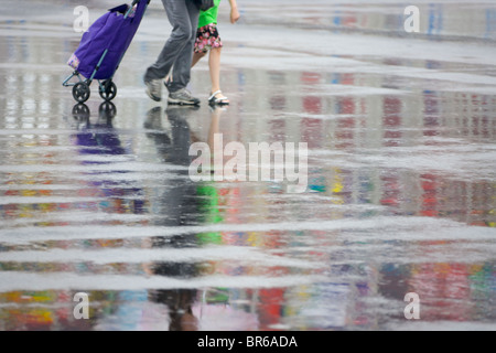 Reflexion der Menschen und Flag Pole auf dem Boden im Regen, Expo 2010 Shanghai, China Stockfoto