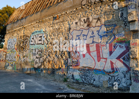 Sonnenuntergang auf einer Steinmauer Gebäude bedeckt Graffiti, La Rochelle, Frankreich. Stockfoto