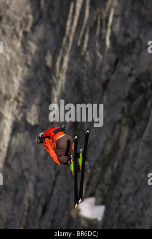 Ein männliche Ski BASE-Jumper springt ein 800 Fuß Granitklippe im Winter. Stockfoto