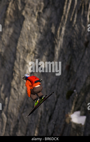 Ein männliche Ski BASE-Jumper springt ein 800 Fuß Granitklippe im Winter. Stockfoto