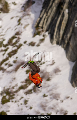 Ein männliche Ski BASE-Jumper springt ein 800 Fuß Granitklippe im Winter. Stockfoto