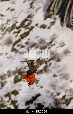 Ein männliche Ski BASE-Jumper springt ein 800 Fuß Granitklippe im Winter. Stockfoto