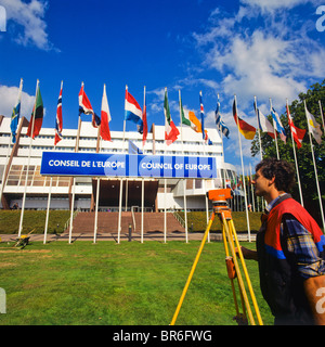 Landvermesser Maßnahmen mit einem Theodolit vor Gebäude vom Europarat, Straßburg, Elsass, Frankreich Stockfoto