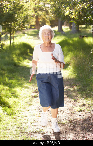 Ältere Frau im Park joggen Stockfoto