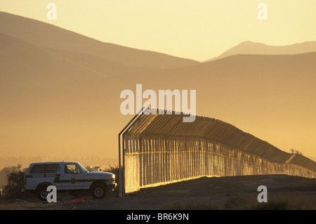 Eine US-Patrouille-Fahrzeug sitzt durch einen Zaun in San Ysidro CA bei Sonnenuntergang. Stockfoto