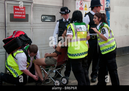 Polizei und St John Ambulance Sanitäter Behandlung von Frau Notting Hill Carnival Stockfoto