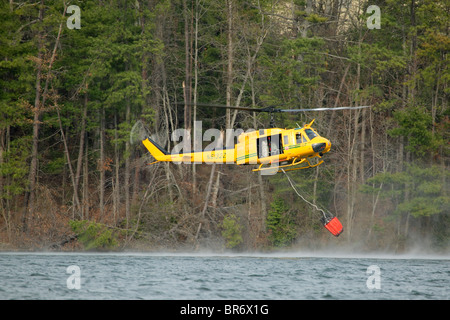 NC-Forstverwaltung Hubschrauber taucht seine Schaufel in See Julian während des Kampfes ein Feuer in der Nähe von Arden NC. Stockfoto
