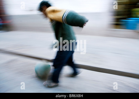 Ein kleiner Junge spielt Fußball auf der Straße in Pisac Peru (Motion Blur). Stockfoto