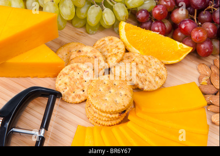 Ein Tablett mit Käse und Obst Snacks bestehend aus Cheddar-Käse, Cracker, Trauben und Orangen. Stockfoto