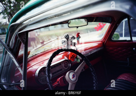 Ein Sammelsurium von kubanischen Kitsch personalisiert das Innere eines lokalen Oldtimers in Santiago De Cuba. Stockfoto