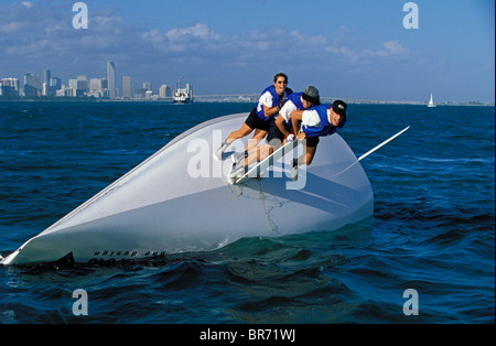 Drei Besatzungsmitglieder einer gekenterten 21 Fuß Viper One-Design Kielboot, balancieren auf dem Kiel in einem Versuch, das Boot richtig. Stockfoto