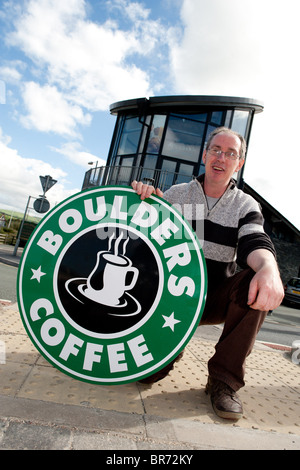 DEREK EDWARDS, der Besitzer von Felsbrocken Cafe, Borth, Wales UK, mit dem Zeichen für sein Café, das er gehabt hat, zu entfernen Stockfoto