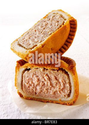 Traditionelle britische Schweinefleischkuchen, geschnitten und bereit, auf weißem Hintergrund zu essen Stockfoto
