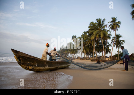 Fischer ziehen Netze an einem Strand in Ghana Stockfoto