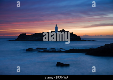 Blick über den Felsen Godrevy Lighthouse Point bei Sonnenuntergang mit brechenden Wellen St Ives Bay Cornwall UK Stockfoto