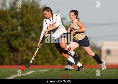 Ein katholische Universität Spieler steuert den Ball gegen Juniata College während der Landmark Konferenz Feldhockey-Meisterschaft. Stockfoto