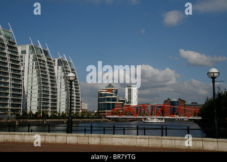 Blick auf modernen Bürogebäuden und Wohnungen in Salford Quays, Manchester, England mit roten Brücke im Vordergrund. Stockfoto