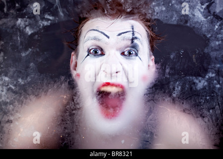 Furchtsames Gesicht schreien Mime für trübe Glas closeup Stockfoto