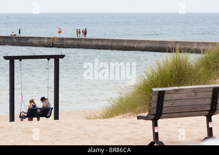 Frankfort Lake Michigan am MI Great Lakes junge Menschen, die auf einer Schaukel an einem Sandstrand schwingen, Uferlinie Rückansicht Wasserlandschaft horizontal in den USA hochauflösend Stockfoto