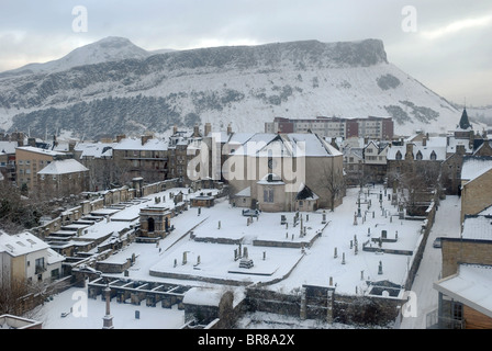 Eine winterliche Stadtlandschaft, suchen im Laufe des 17. Jahrhunderts Canongate Kirk in Richtung Salisbury Crags und Arthurs Seat in Edinburgh. Stockfoto