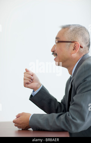 Geschäftsmann am Schreibtisch sitzen, weißer Hintergrund Stockfoto