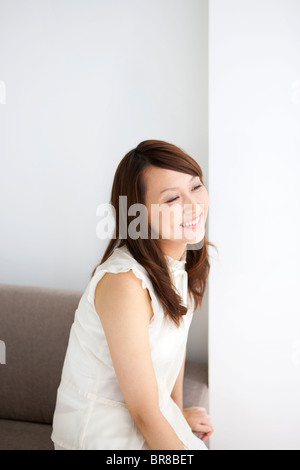 Frau sitzt auf dem sofa Stockfoto