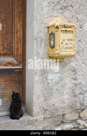 Briefkasten an der Wand und Schwarze Katze sitzt an der Tür, Midi Pyrenees, Frankreich