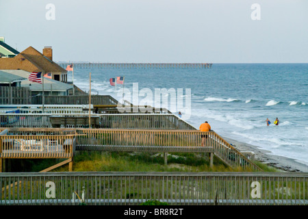 Häuserzeile am Strand mit US-Flaggen im Wind Topsail Beach North Carolina Outer Banks. Stockfoto