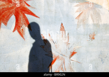 Schatten des Mannes auf Wand Royal Canadian Legion Gebäude mit fallenden lackierten Ahornblätter, Vancouver, Britisch-Kolumbien, Kanada Stockfoto