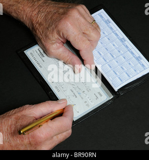 Ältere Menschen mans Hände schreiben zehn tausend-Dollar-Scheck aus unabhängigen National Bank Florida USA Stockfoto