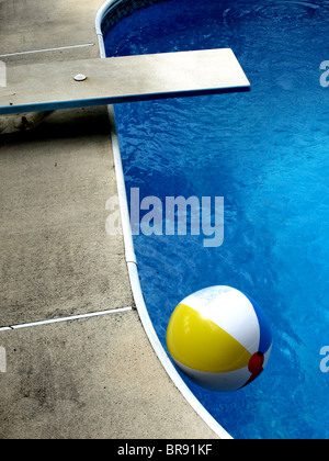 Rand des Hause Inboden Swimmingpool mit blauem Wasser-Zement deck, Tauchen und Beachball Stockfoto