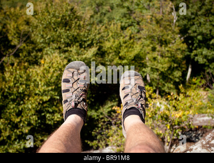 Wanderer sieht in den Shenandoah auf eine Besteigung des alten Lappen über Tal mit Füßen an der Kante hängen Stockfoto