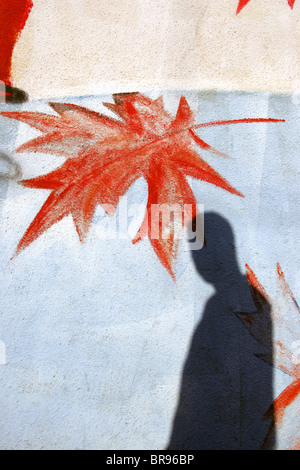 Schatten des Mannes auf Wand Royal Canadian Legion Gebäude mit fallenden lackierten Ahornblätter, Vancouver, Britisch-Kolumbien, Kanada Stockfoto