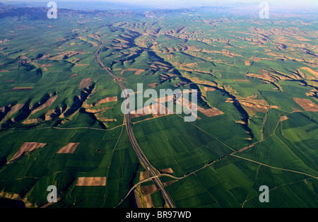 Ackerland und Autobahn. Luftaufnahme von Bureba Region. Burgos. Kastilien-León. Spanien. Stockfoto