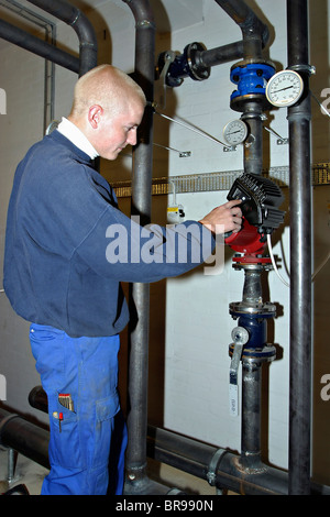 Junge Heizung und Sanitär-Techniker einstellen eine Umwälzpumpe Stockfoto