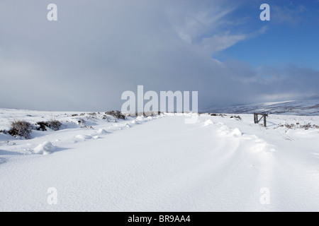 Schneebedeckte Straße auf Kildlae Moor in North York Moors National Park mit einem Schneesturm nähert sich Stockfoto