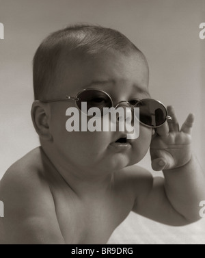 1960ER JAHRE BABY TRAGEN OMA BRILLE SONNENBRILLE Stockfoto