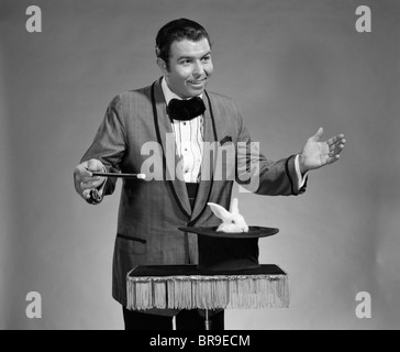 1960ER JAHRE MANN MAGIER TRAGEN SMOKING WEIßE KANINCHEN ERREICHTE UNSERE TOP HUT Stockfoto