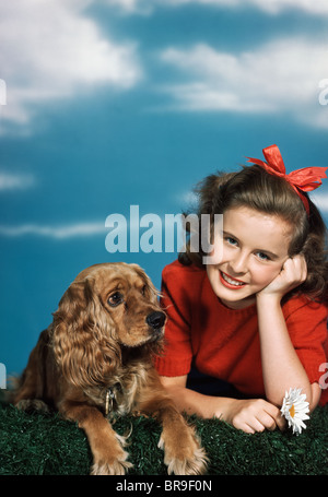 1940S 1950S LÄCHELND TEEN MÄDCHEN MIT COCKER SPANIEL HUND Stockfoto