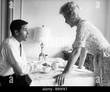 1950S 1960S MANN UND FRAU STREITEN AM FRÜHSTÜCKSTISCH INDOOR Stockfoto