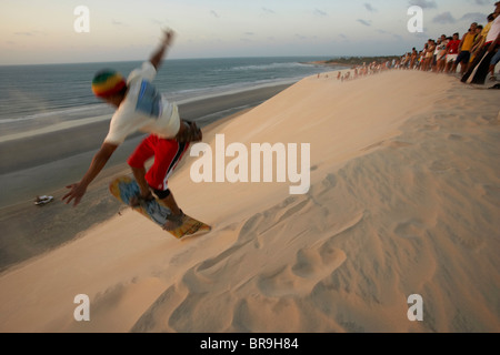 Brasilianischen Mann Sandboarding springt Düne, während ein Publikum Jericoacoara Brasilien beobachtet. Stockfoto