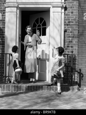 1930ER JAHREN KINDER JUNGEN UND MÄDCHEN WINKEN AUF WIEDERSEHEN, FRAU MUTTER Stockfoto