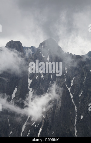 Steigender Nebel niedrigen Wolken wirbelt um Els Encantats Höhepunkt von d'Amitges in Sant Maurici Nationalpark Pyrenäen Spanien gesehen Stockfoto