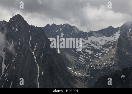 Steigender Nebel niedrigen Wolken wirbelt um Els Encantats Höhepunkt von d'Amitges in Sant Maurici Nationalpark Pyrenäen Spanien gesehen Stockfoto