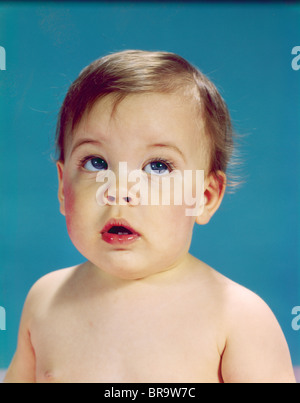 1960ER JAHRE BABY MIT UNSICHEREN GESICHTSAUSDRUCK AUGEN NACH OBEN UND ZUR SEITE Stockfoto