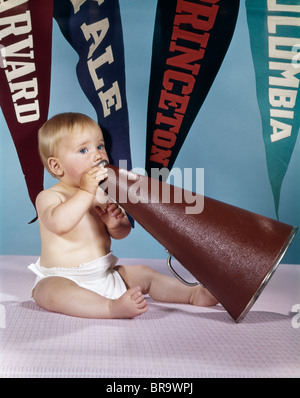 1960ER JAHREN BABY-GESCHREI IN CHEERLEADER MEGAPHON COLLEGE WIMPEL IM HINTERGRUND Stockfoto