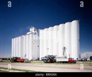 1970ER JAHREN WEIßE GETREIDESILOS LKW PARKTE VOR SILOS GEGEN BLAUEN HIMMEL Stockfoto